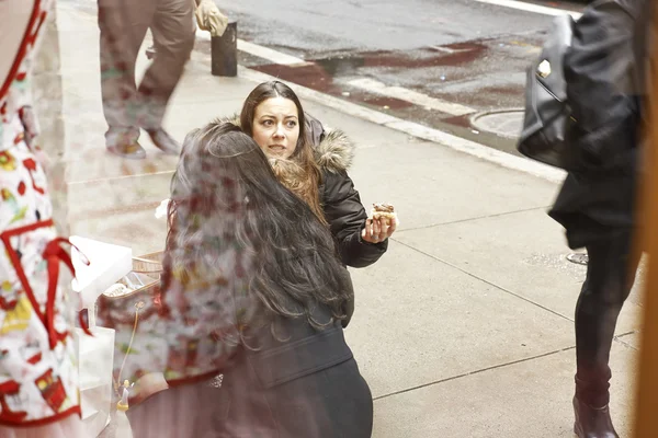 New York, USA - December 09, 2013: Urban life in Manhattan, pretty woman on street eating sweets from shop. — Stock Photo, Image