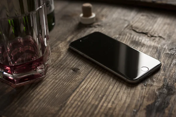 Smartphone on wooden table with whiskey — Stock Photo, Image
