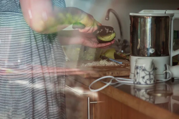 Женщина режет авокадо — стоковое фото