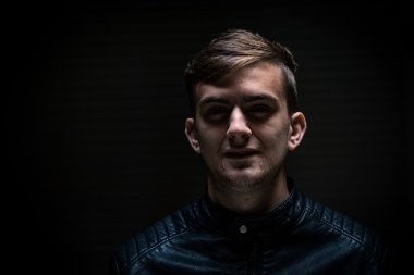 Karanlık arka plandaki genç adam.