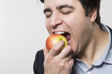 studio shot of happy person eating an apple