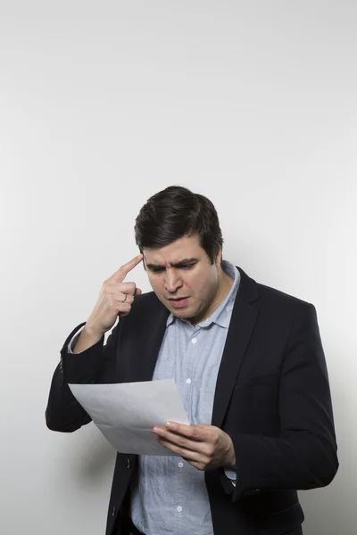 Studio shot of angry businessman reading a paper — Φωτογραφία Αρχείου