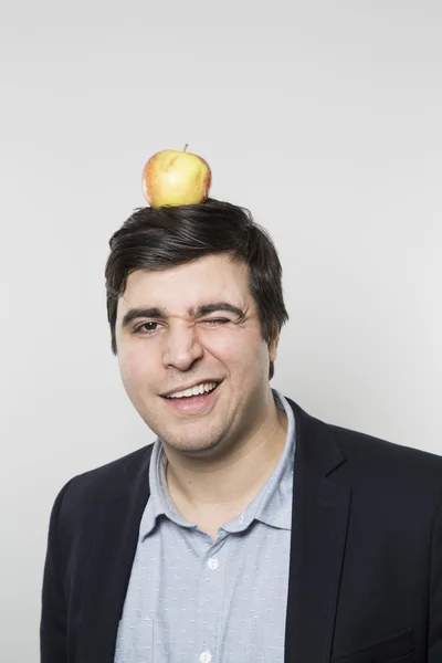 Plan studio d'une personne heureuse avec une pomme sur la tête — Photo