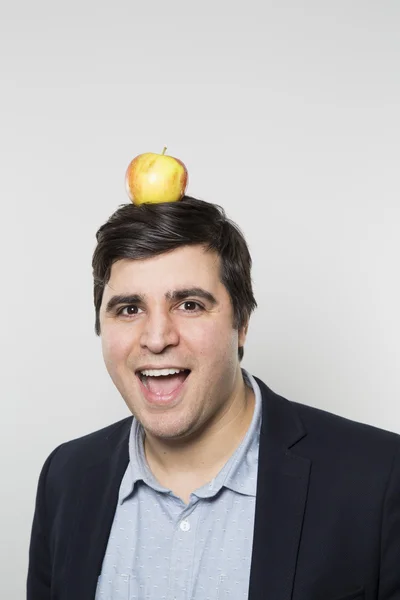 Studio shot of happy person with an apple on his head — Stock fotografie