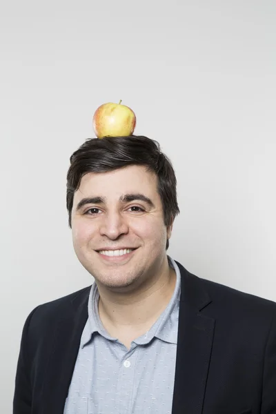 Studio shot of happy person with an apple on his head — Stock Fotó