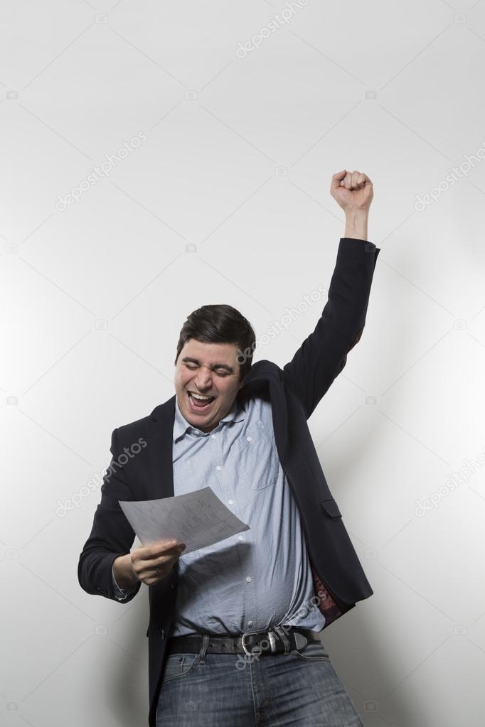 studio shot of happy businessman celebrating a paper