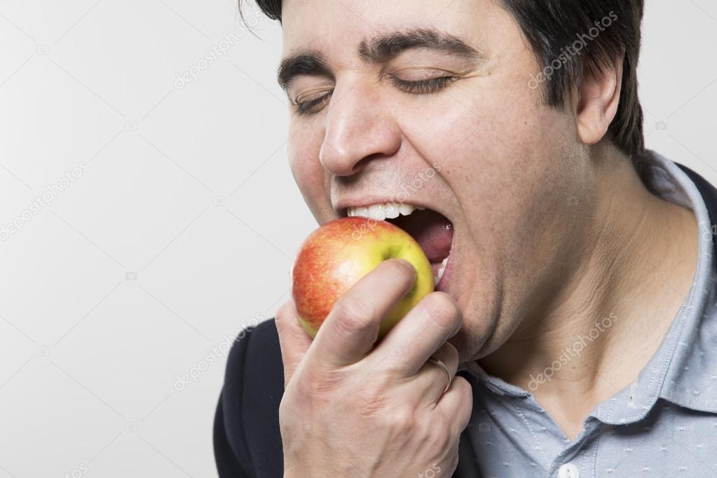 studio shot of happy person eating an apple