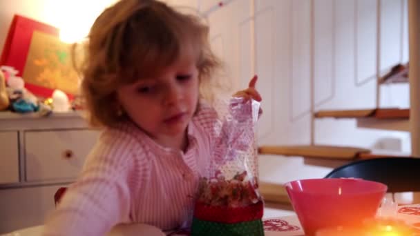 Flicka fyller cookies i en påse på advent först — Stockvideo