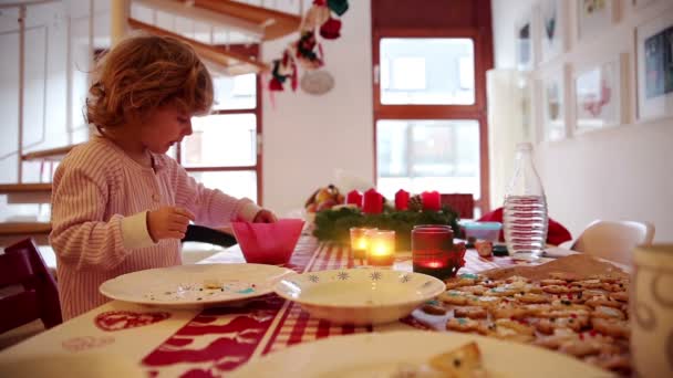 Flicka hjälper till med cookie förberedelsen på advent först — Stockvideo