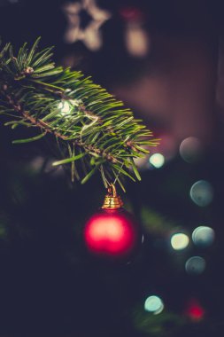 Arka planda ışıklar olan bir Noel ağacında Kırmızı bir Bauble 'ın Kapanışı