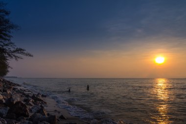 Sunrise manzara kenarı Yüzme kişi ile kum plaj.