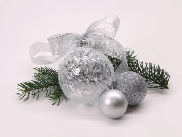 Silver Christmas balls with a bow and fir branches on a white background