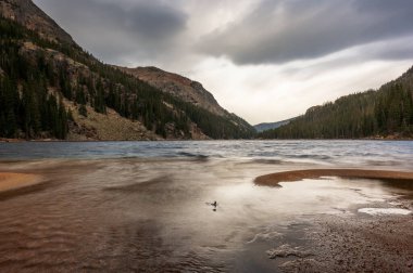 Kayalık Dağ Ulusal Parkı 'ndaki yüksek rakımlı bir alp gölü olan Verna Gölü' nün sahil şeridine uzun süreli su vuruyor.