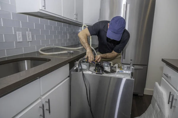 Reparador Eletrodomésticos Trabalhando Uma Máquina Lavar Louça Instalando Mangueiras Água — Fotografia de Stock