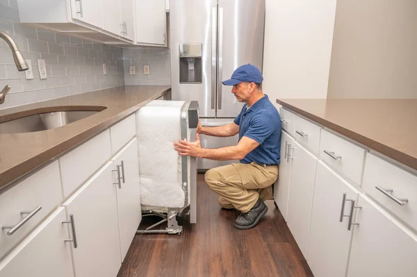 현대식 주방에 식기세척기를 설치하는 수리공 — 스톡 사진