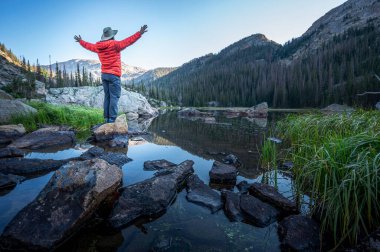 Maceraperest bir yürüyüşçü, Colorado 'daki Rocky Mountain Ulusal Parkı' ndaki Bench Gölü drenajında bir kayanın üzerinde duruyor.