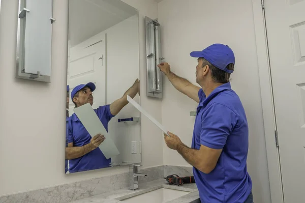 Handyman Electricista Cambiando Una Bombilla Vertical Baño Moderno — Foto de Stock