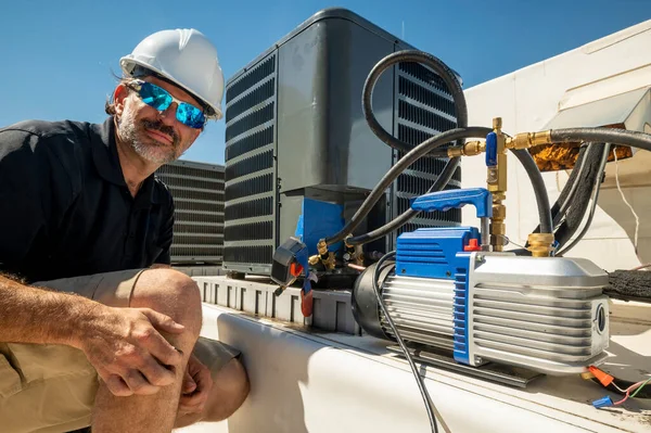 空調の修理のための避難ツールの横に カメラを見てHvac技術者 ロイヤリティフリーのストック画像