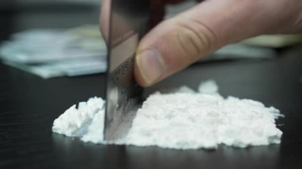 Close up of addict hand is chopping crack cocaine powder with bank credit card.Concept of addiction and drug abuse concept. Člověk dělá kokainovou cestu. Řádky kokainového prášku na černém stole — Stock video