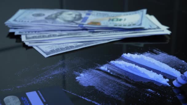 Drugs, cocaïne, geld. Onherkende persoon snuift lijn van wit drugspoeder door gerold US dollar biljet van de zwarte tafel. Verslaafde gebruikt drugs. Verslaving, sociale vraagstukken en drugsgebruik — Stockvideo