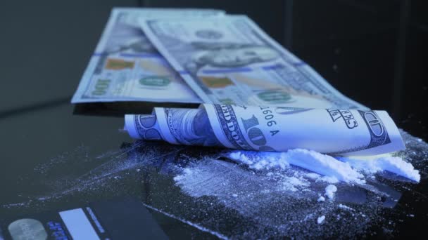 O homem está derramando nota de 100 dólares americanos na mesa preta com linhas de pó de drogas brancas. A nota rolada dos EUA está deitada em linhas de pó de droga. Cocaína, anfetamina, metanfetamina. Conceito de abuso de substâncias — Vídeo de Stock