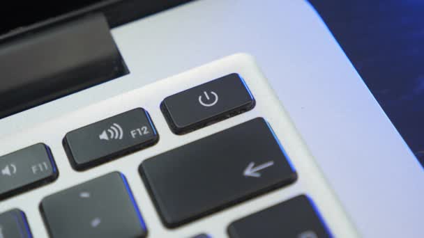 Az ujj megnyomja a gombot, hogy bekapcsolja a laptopot. A férfi bekapcsolja az áramot a laptopon. A személy megnyomja a laptop bekapcsológombját — Stock videók