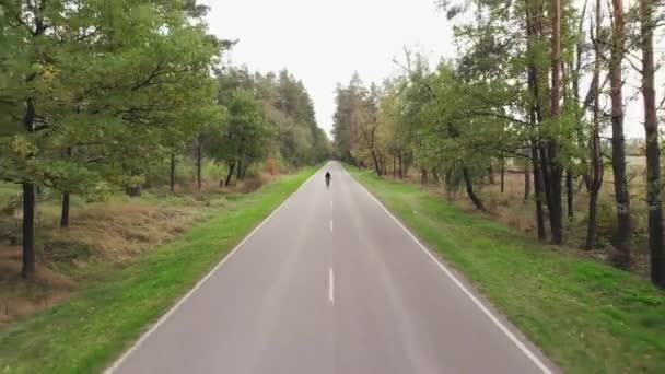 Enfocado motivado ciclista profesional está corriendo en bicicleta de carretera aerodinámica al aire libre. Joven en ropa de ciclismo negro está haciendo ejercicios de entrenamiento en bicicleta, preparándose para la carrera en bicicleta. — Vídeos de Stock