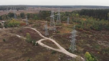 Şehirlerarası iletişim hatları. Ormanda yüksek voltajlı sütunlar. Güç iletim kolonları. Yeşil kırsal kesimde elektrik hatları. Elektrik ve çevresel sorun kavramı. Yeşil enerji