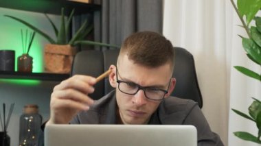 Depresyondaki umutsuz iş adamı iş yerindeki mali sorunlardan endişe duyuyor, para borcunu düşünürken hayal kırıklığına uğramış görünüyor. Gözlüklü stresli genç adam, görevleri yüzünden bunalmış durumda.