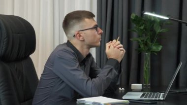 Çaresiz iş adamı şirketteki mali sorunlar için endişeleniyor. Stresli işadamı başka yere bakıyor, hayal kırıklığına uğramış hissediyor, ofis masasında oturan borç ve iflası düşünüyor.