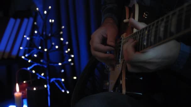 Hudebník hraje sólovou kytarovou roli na elektrické kytaře. Detailní záběr mužských rukou hrát na struny s kytarovým krumpáčem. Kytarista hraje lyrickou milostnou píseň na kytaru v nahrávacím studiu — Stock video