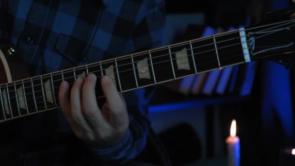 Mann spielt E-Gitarre in Wiederholungshalle. Gitarrist spielt Rockmusik auf der Gitarre im dunklen Tonstudio. Männlicher Musiker probt Konzertprogramm. Handspiel auf den Saiten der Gitarre — Stockvideo