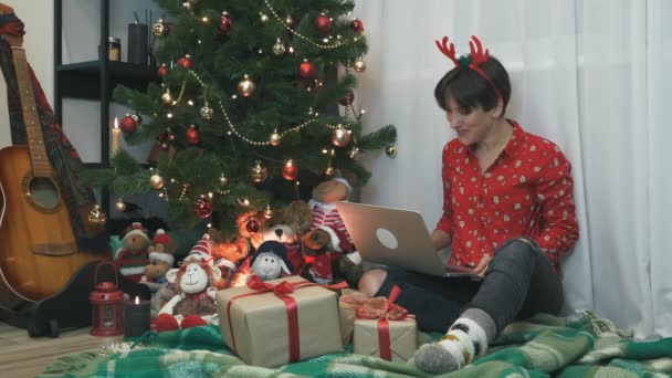 Sonriente mujer feliz está celebrando la Navidad y Año Nuevo festivos días festivos solo en casa durante la cuarentena, haciendo webcam videoconferencia con la familia, hablando y riendo. Feliz Año Nuevo 2021 — Vídeo de stock