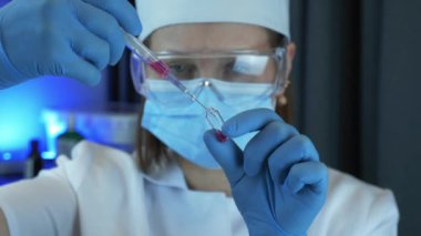 Hastanede doktorun ellerinde şırınga ve aşıyla tüp var. Sağlık ve tıbbi kavramlar. Bilim adamı şırıngadan ebola aşısı dolduruyor. Doktor mikrobiyolog laboratuvarda araştırmacı bilim adamı.