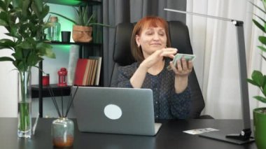 Başarılı zengin iş kadını ofiste oturarak Amerikan dolarlarını saçıyor. Mutlu gülümseyen, heyecanlı kadın muhasebeci para saçıyor. İş ve finans kavramı