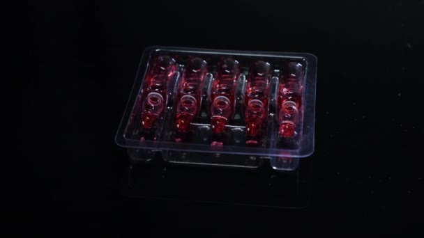 Vaccine ampoules with medicine on black background, close-up. Modern medicine. Injection Bottles, rotation shot. — Stock Video