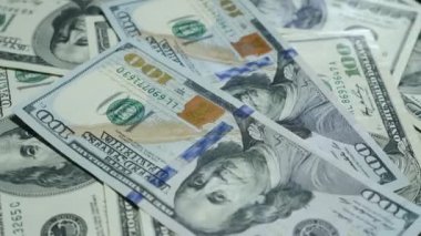 Amerikan para birimlerinin banknotları masanın üzerinde dönüyor. Kapatın. Dolarlar dönüyor. Paralı arka plan Amerikan 100 dolarlık banknotlar. Finans kavramı