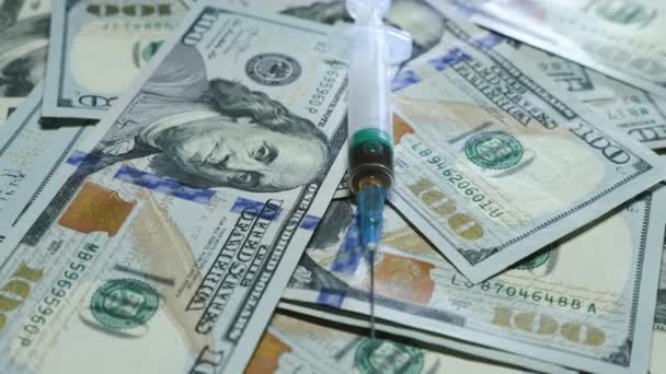 На фоне долларовых купюр и шприца. Банкноты в долларах США на столе, крупным планом. Незаконный оборот наркотиков, незаконный бизнес. Концепция наркомании и здравоохранения — стоковое видео