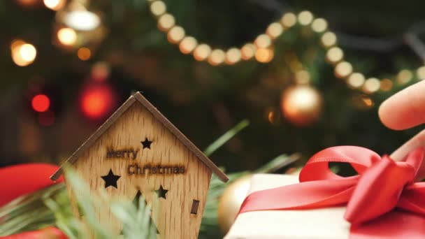 Közelről karácsonyi ajándék doboz piros szalaggal az újévi fa alatt. Karácsonyi dekoráció fényben. Boldog téli ünnepeket! — Stock videók