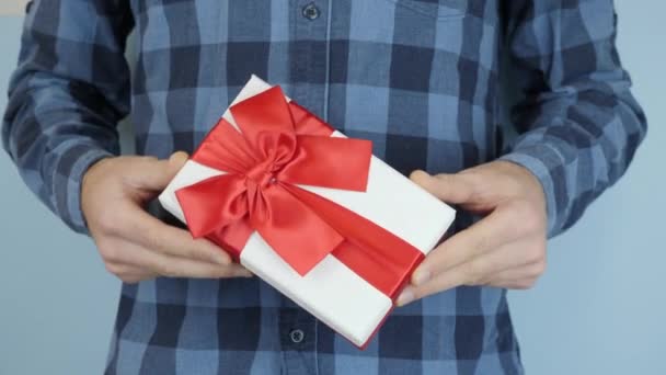 情人节或生日，男士们的手都拿着红丝带蝴蝶结的礼品盒。人手里拿着捆着的弓,手里握着它.圣诞礼物 — 图库视频影像