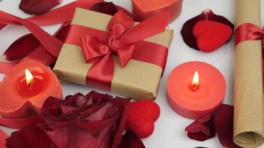 Decorated romantic background with burning candles, roses and presents gift boxes. St. Valentine's Day surprise. Celebration of 14th of February. Holiday surprise. Romantic greeting