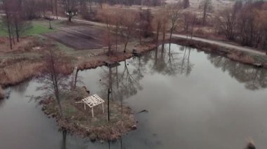 Çam ağacı ormanındaki küçük göl üzerinde uçan drone. Aktif maceralar. Göl kenarındaki çakıl bisikletli adamların hava manzarası