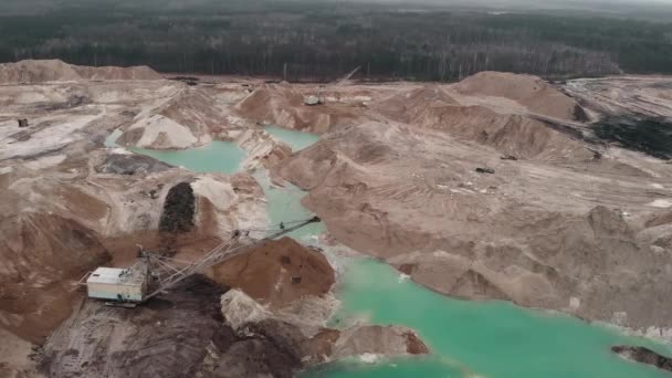 Obří rypadlo pracuje v lomu písku, střela z bezpilotního letounu. Obrovský průmyslový důlní lom s pískem a jezery. Opencast lom s velkým rypadlem v práci. Bagry nakládají písek — Stock video