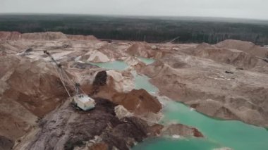 Büyük kazıcının üst görüntüsü kum ocağında çalışır, kum yükler ve gölden kum taşır. Endüstriyel maden ocağı. Taş ocağı çıkarıcı sanayi. Kum ocağı, inşaat endüstrisi için kum çıkarma.