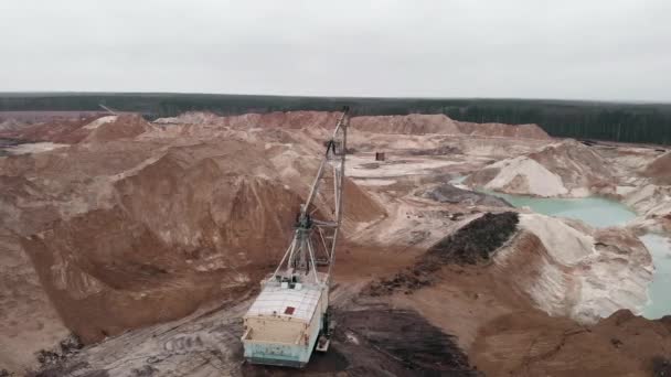 Obrovský průmyslový bagr nakládá a přepravuje písek v lomu těžby. Strojní rypadlo pracuje ve velkém těžebním lomu. Těžba nerostných surovin — Stock video