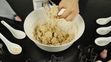 Kadın eli karıştırıcı bıçaklardan çiğ hamur parçaları çıkarır, baharatlı zencefilli kurabiye ya da bisküvi yapar. Ev yapımı pasta veya fırın hazırlama süreci
