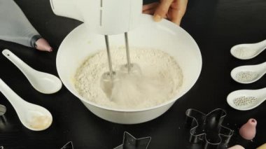 Elektrikli mikser hamuru kaseye karıştırıyor, kapat. Kadın blender kullanarak zencefilli ekmek hamuru yapıyor. Kurabiye ya da hamur işi yapma süreci. Kadınlar Sevgililer Günü için kurabiye yapar.