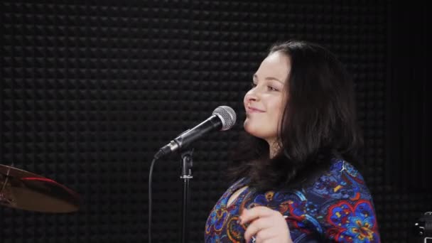 Wanita yang gembira bernyanyi ke mikrofon, menari dan bersenang-senang di studio suara — Stok Video