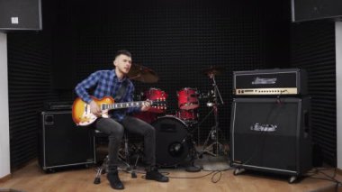 Müzisyen ses stüdyosunda elektro gitarda aşk şarkısı söylüyor.