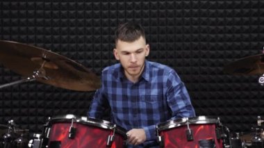 Genç müzisyen modern prova müzik stüdyosunda davul setiyle çalar.